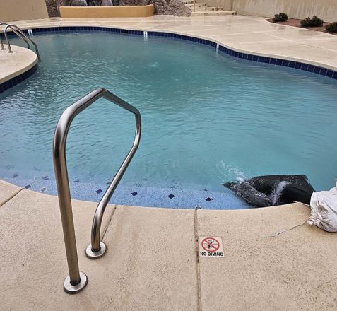 Curved pool with metal ladder, "NO DIVING" sign, and a bag near the edge.